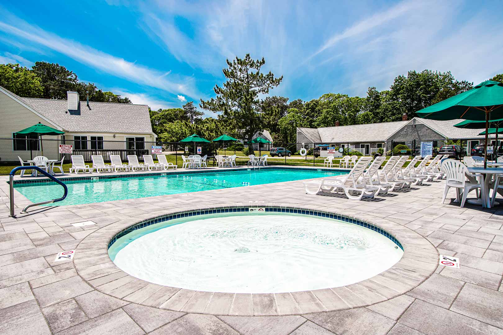 A serene view of the outside swimming pool and jacuzzi at VRI's Brewster Green Resort in Massachusetts.